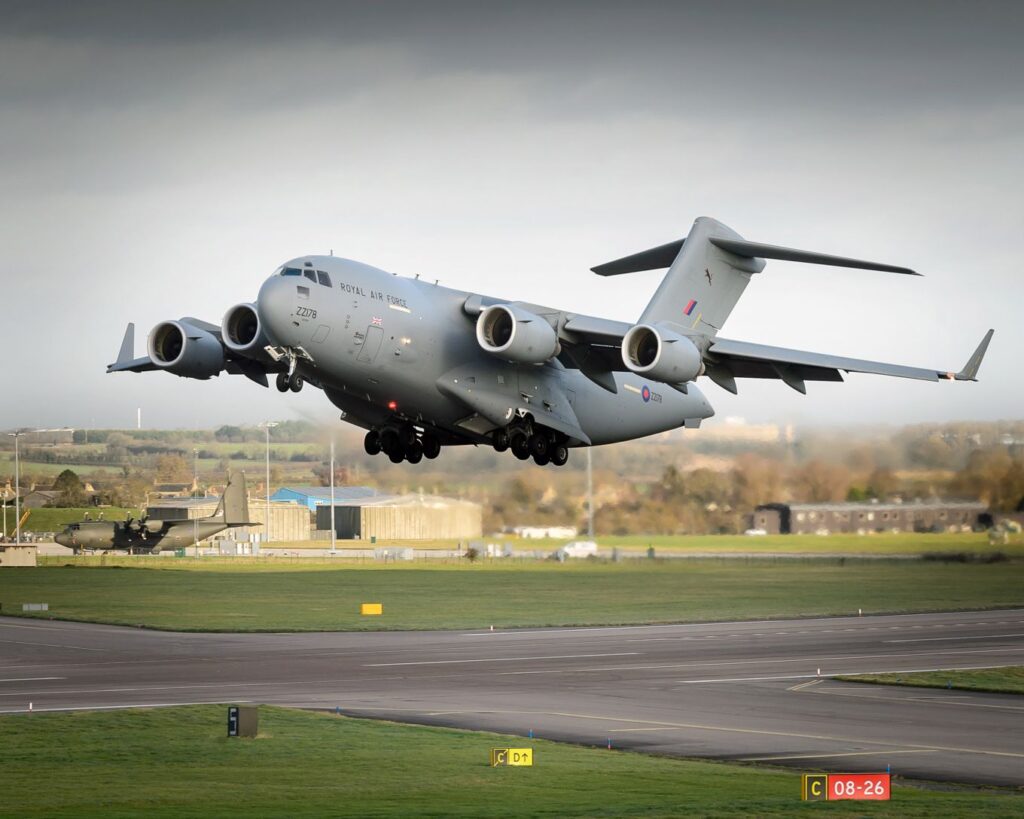 A Royal Air Force 99 Squadron C17 aircraft is taking off from RAF Brize Norton providing air transport assistance to France for the Central African Republic (CAR).



The C17 is capable of rapid, strategic delivery of troops and all types of cargo to main operating bases anywhere in the world, or directly to more temporary forward operating bases owing to its short field capability. The design of the aircraft allows it to carry out high-angle, steep approaches at relatively slow speeds, thus allowing it to operate into small, austere airfields onto runways as short as 3,500 feet long and only 90 feet wide. 



The aircraft can operate into and out of problematic sites such as those surrounded by inhospitable terrain or made difficult by adverse weather conditions. The fully-integrated, electronic flight-deck and the advanced cargo-handling systems allow a basic crew of only two pilots and one air loadmaster to operate the aircraft. 



On the ground, the aircraft can be turned in a very small radius and its four Pratt & Whitney engines are fully reversible, giving it the ability to manoeuvre into and out of restricted parking or freight-offload areas at undeveloped strips. 



This enables the C-17 to deliver cargo to small airfields with limited parking space in a shorter time, so increasing throughput where time on the ground is kept to a minimum. The C-17 can transport 45,360kgs of freight over 4,500 nautical miles whilst flying at heights in excess of 30,000 feet.